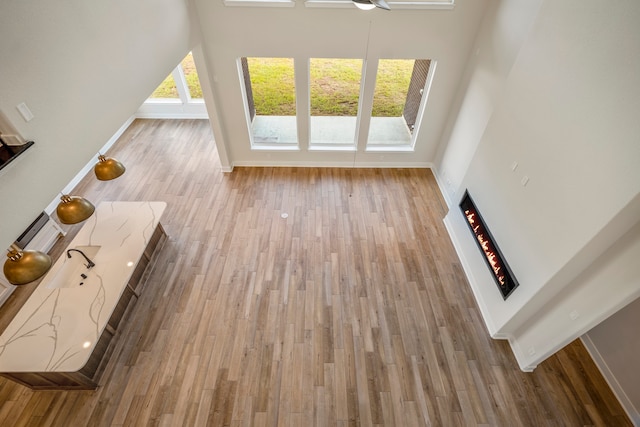 unfurnished living room featuring a high ceiling and hardwood / wood-style floors