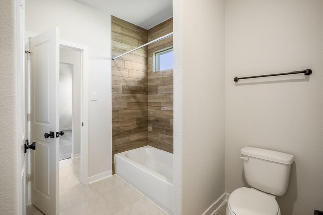 bathroom featuring toilet, tiled shower / bath, and tile patterned flooring