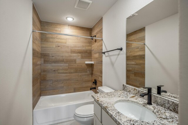 full bathroom with vanity, wooden walls, tiled shower / bath combo, and toilet