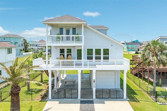 back of property featuring a balcony, a garage, and a lawn