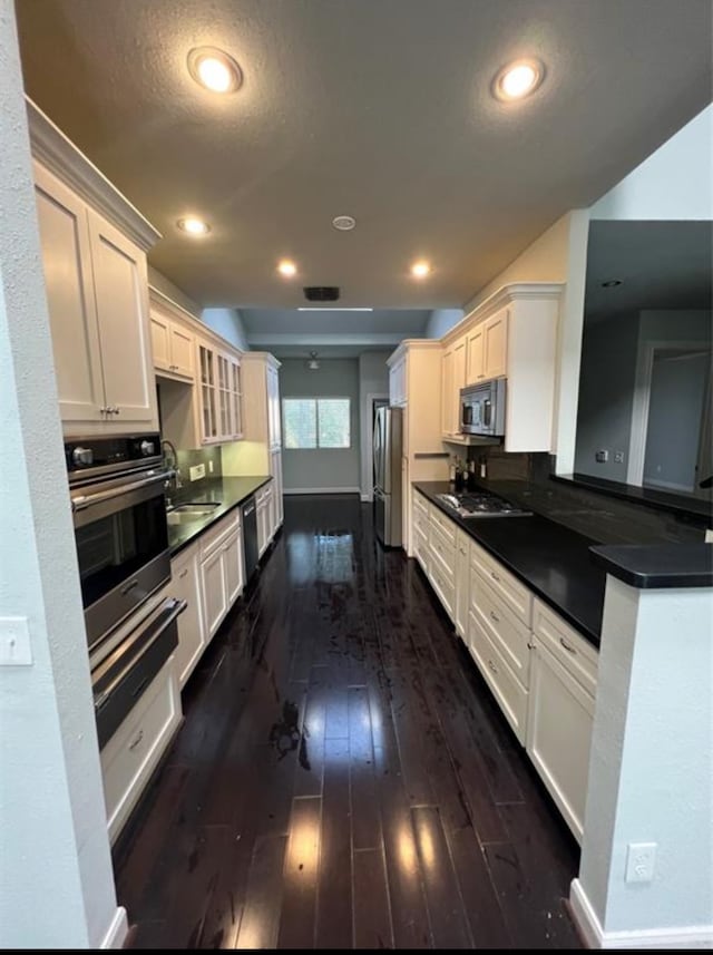 kitchen featuring white cabinets, stainless steel appliances, dark wood-type flooring, and sink