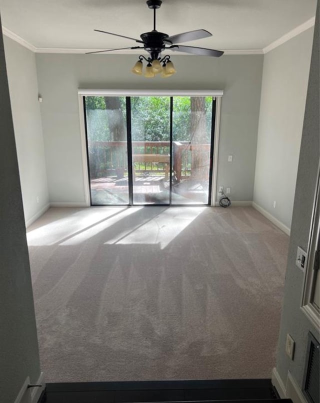 spare room with ceiling fan, light colored carpet, and ornamental molding