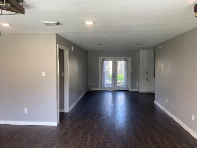 spare room featuring french doors, dark hardwood / wood-style flooring, and a textured ceiling