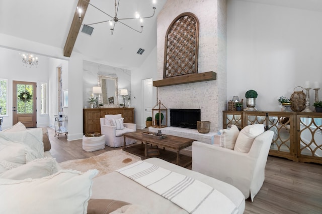 living room featuring a fireplace, light hardwood / wood-style floors, beamed ceiling, and high vaulted ceiling