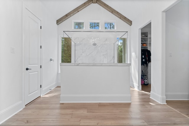 entrance foyer with vaulted ceiling with beams and light hardwood / wood-style flooring