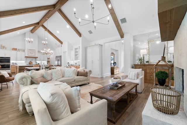 living room featuring high vaulted ceiling, light hardwood / wood-style flooring, beamed ceiling, and an inviting chandelier