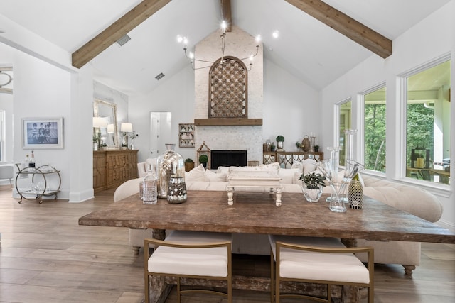 kitchen featuring a fireplace, light hardwood / wood-style floors, beam ceiling, and high vaulted ceiling