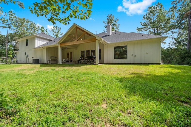 rear view of property with cooling unit, a yard, and a patio area