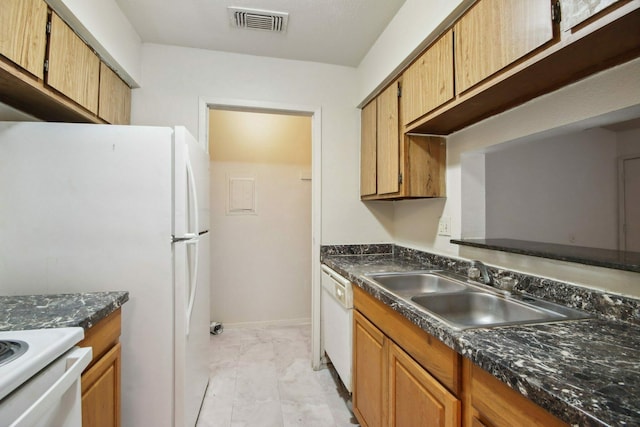 kitchen with dark stone counters, white dishwasher, sink, and light tile patterned floors