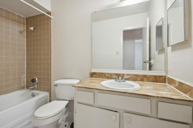 full bathroom with vanity, tiled shower / bath combo, and toilet