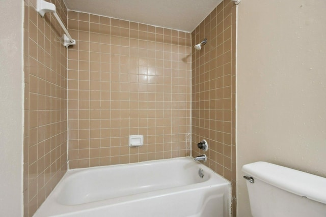 bathroom with tiled shower / bath combo and toilet