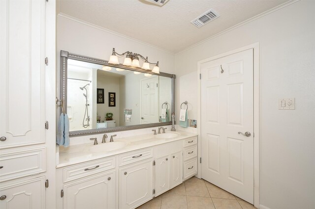 bathroom featuring ornamental molding, tile patterned floors, a textured ceiling, and dual bowl vanity