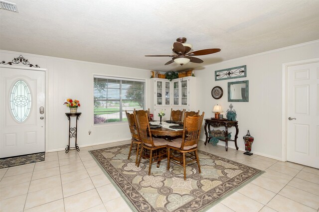 dining area featuring light tile patterned flooring, ceiling fan, and crown molding