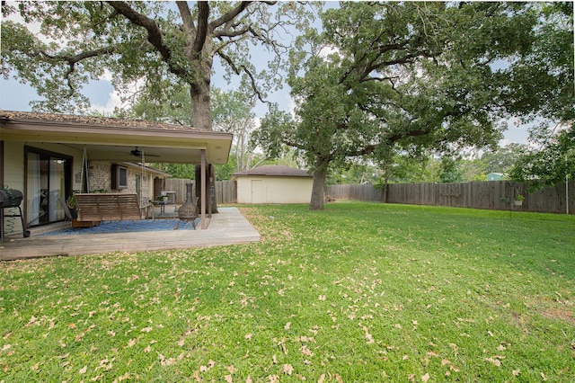 view of yard with an outbuilding, a deck, and ceiling fan