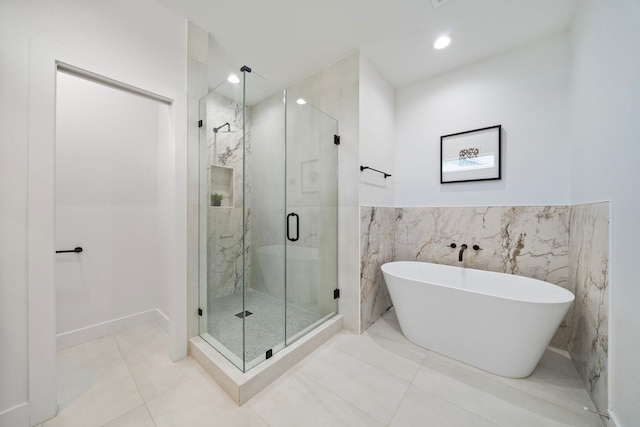 bathroom featuring tile patterned floors, tile walls, and independent shower and bath