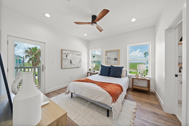 bedroom with hardwood / wood-style floors, ceiling fan, and access to exterior