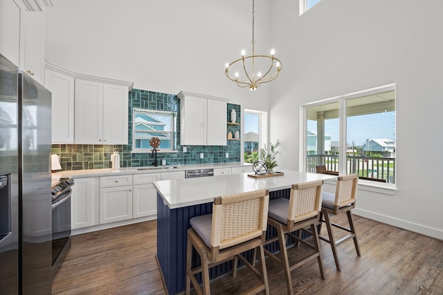 kitchen featuring white cabinets, hanging light fixtures, and dark wood-type flooring