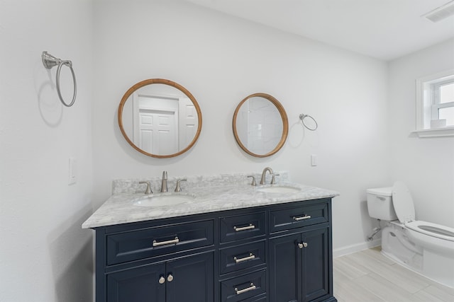 bathroom with dual bowl vanity and toilet