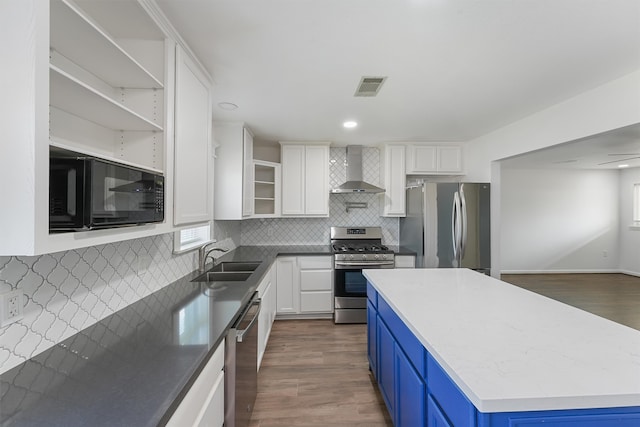 kitchen with wall chimney range hood, backsplash, dark hardwood / wood-style floors, appliances with stainless steel finishes, and sink