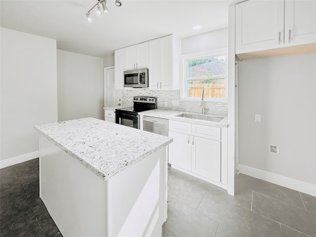 kitchen featuring white cabinets, a center island, stainless steel appliances, sink, and tasteful backsplash