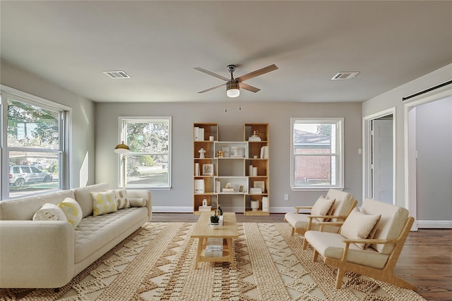 living room with a healthy amount of sunlight, light hardwood / wood-style flooring, and ceiling fan