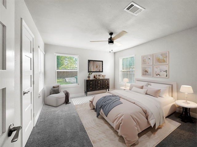 carpeted bedroom featuring a textured ceiling and ceiling fan