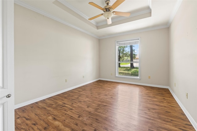 spare room featuring ornamental molding, dark hardwood / wood-style floors, ceiling fan, and a raised ceiling