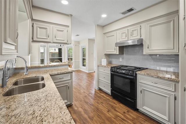 kitchen with sink, light stone counters, dark hardwood / wood-style floors, black range with electric stovetop, and decorative backsplash