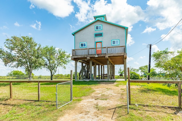 rear view of house with a deck, a rural view, and a lawn