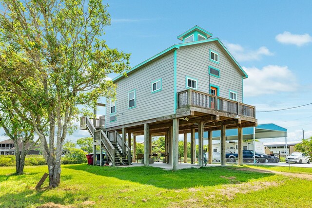 rear view of house featuring a deck and a lawn