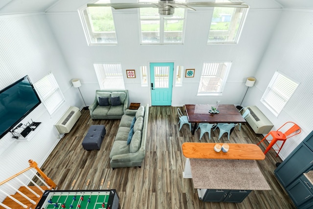 living room featuring dark wood-type flooring, a wall mounted air conditioner, and ceiling fan