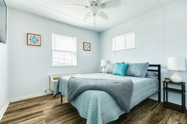 bedroom featuring ceiling fan, dark wood-type flooring, multiple windows, and radiator