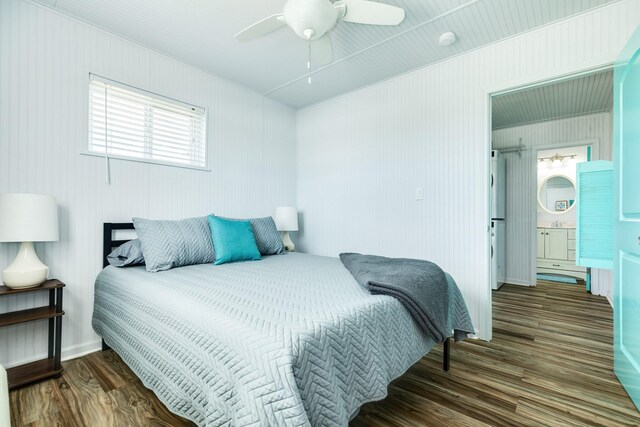 bedroom with ceiling fan, dark wood-type flooring, and ensuite bathroom