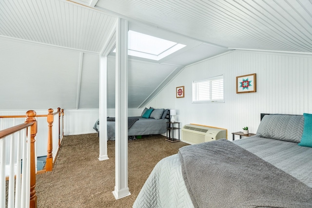 carpeted bedroom with an AC wall unit and lofted ceiling with skylight