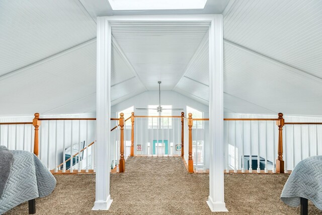 hall with carpet floors and vaulted ceiling