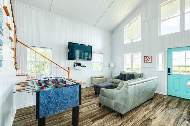 living room with a wall mounted air conditioner, dark wood-type flooring, and high vaulted ceiling