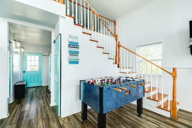 recreation room featuring ornamental molding and dark hardwood / wood-style floors