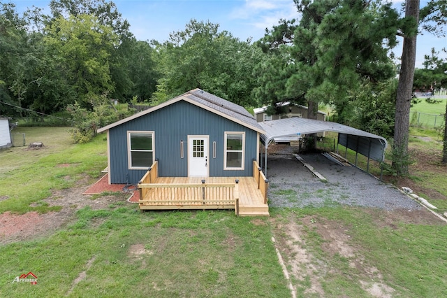 back of house featuring a carport, a yard, and a wooden deck