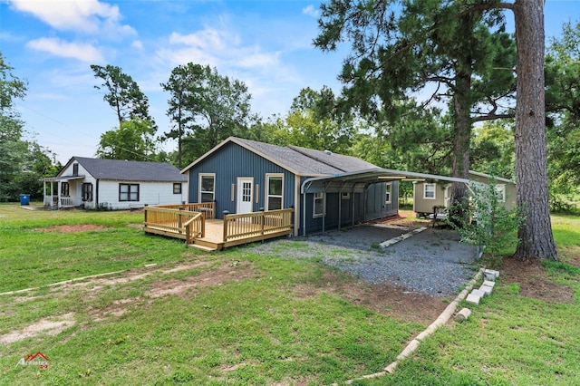 rear view of property with a wooden deck, a yard, and a carport