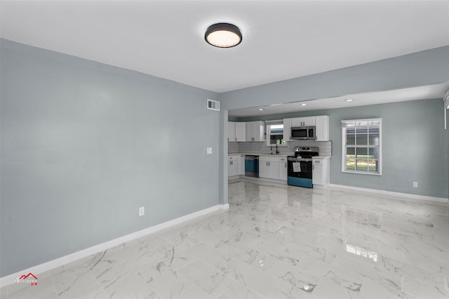 unfurnished living room featuring sink and light tile patterned floors