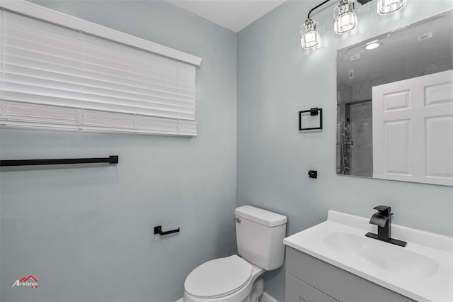 bathroom with vanity, a shower, and toilet