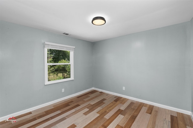 unfurnished room with hardwood / wood-style flooring