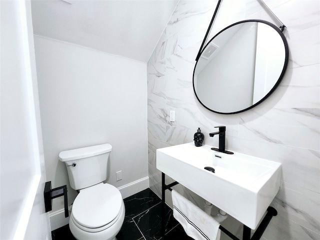 bathroom featuring tile patterned floors, tile walls, and toilet