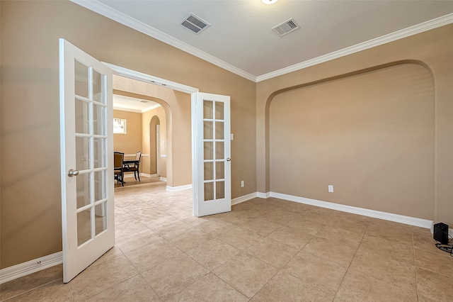 spare room with light tile patterned floors, french doors, and crown molding