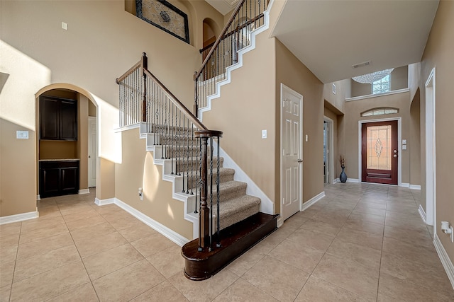 tiled foyer entrance featuring a towering ceiling