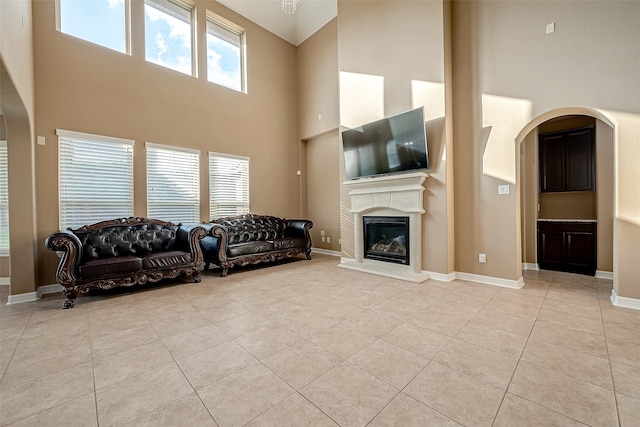 living room featuring a healthy amount of sunlight, a high ceiling, and light tile patterned flooring