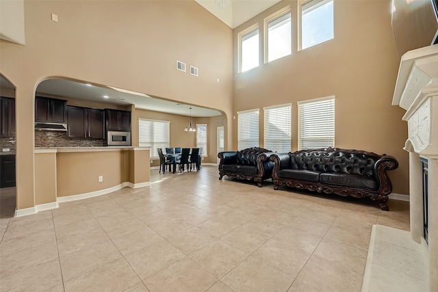 living room featuring light tile patterned floors and a high ceiling