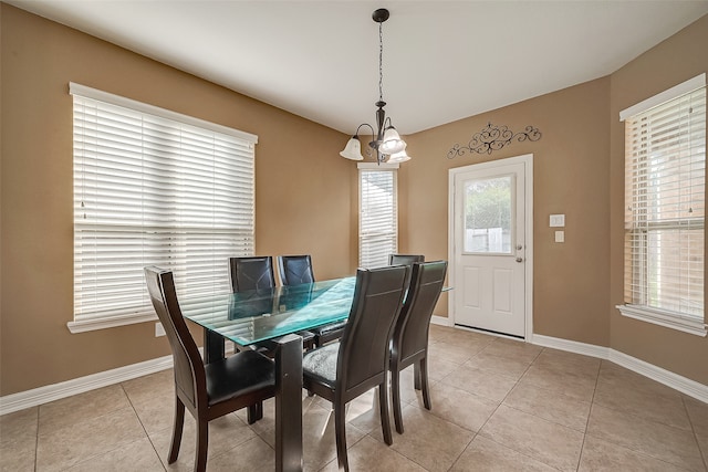 tiled dining space featuring an inviting chandelier