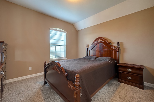 bedroom with vaulted ceiling and light carpet