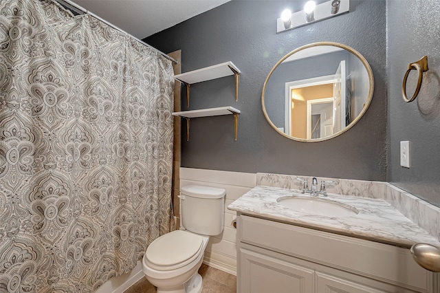 bathroom featuring walk in shower, vanity, toilet, and tile patterned floors